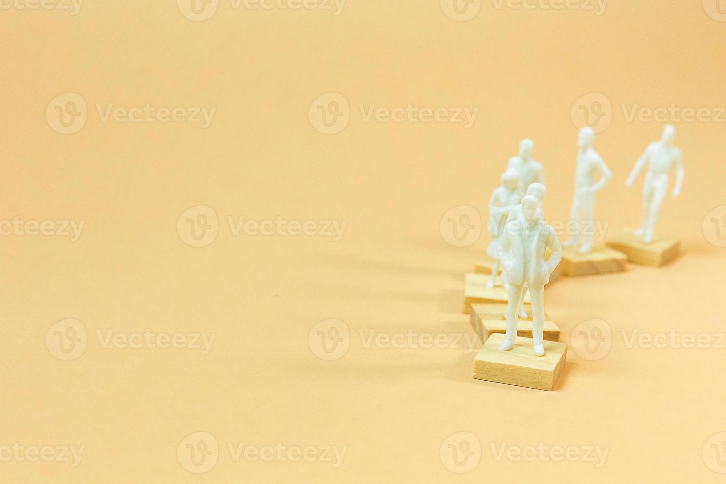 white  figure miniature on orange pastel for business content. photo