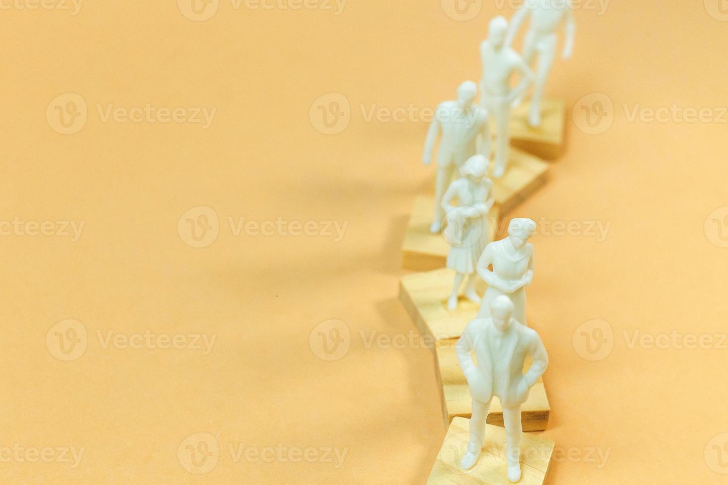 white  figure miniature on orange pastel for business content. photo
