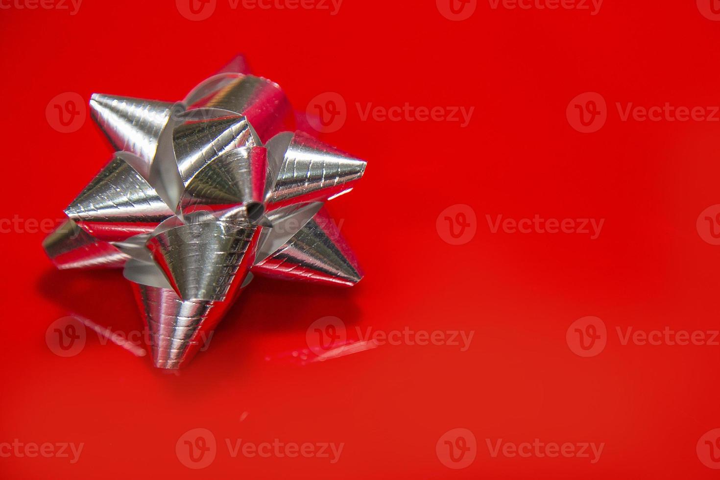 Shiny silver satin ribbon on red background. photo