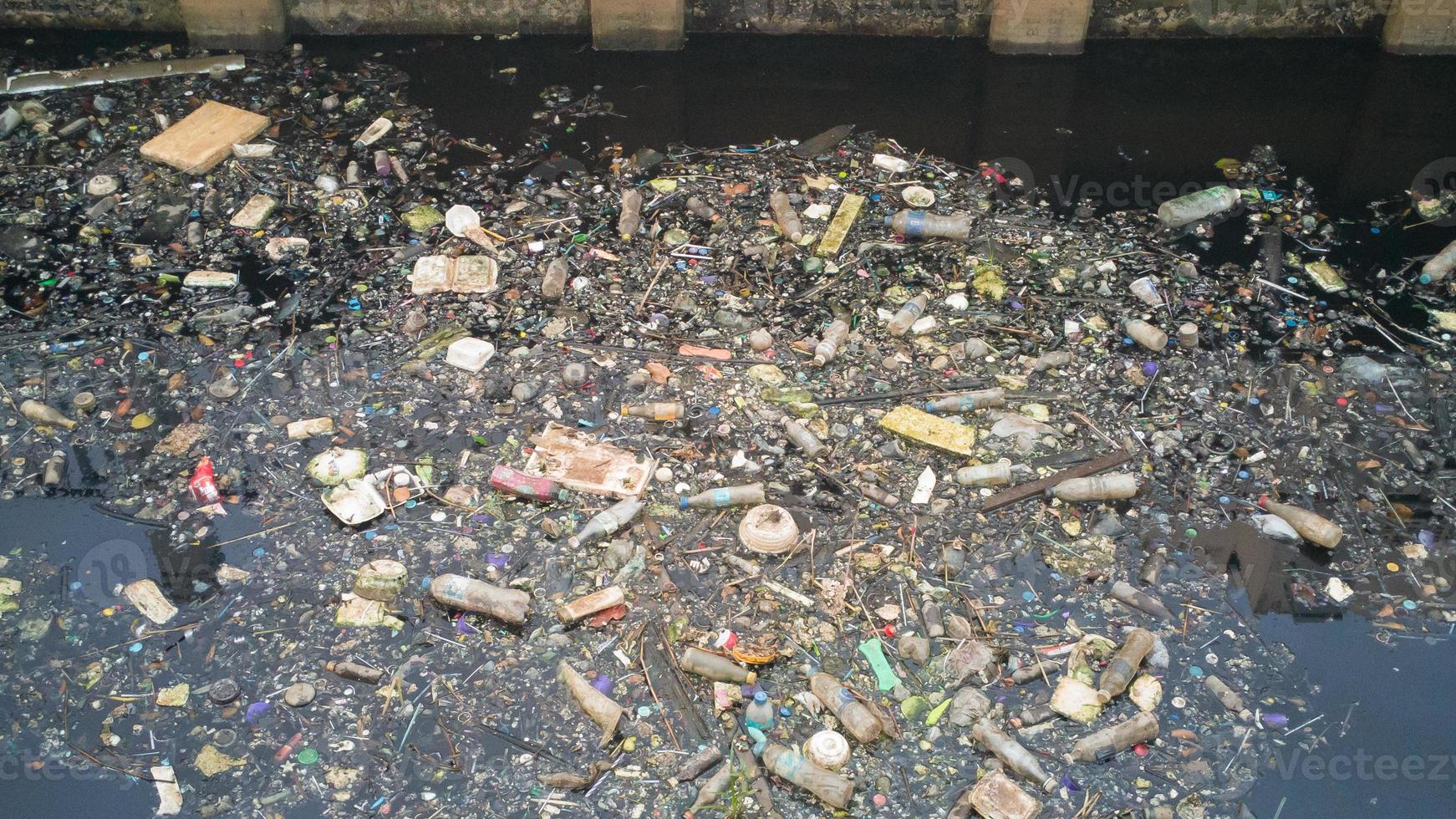 Water pollution effects Dirty garbage in canal. photo