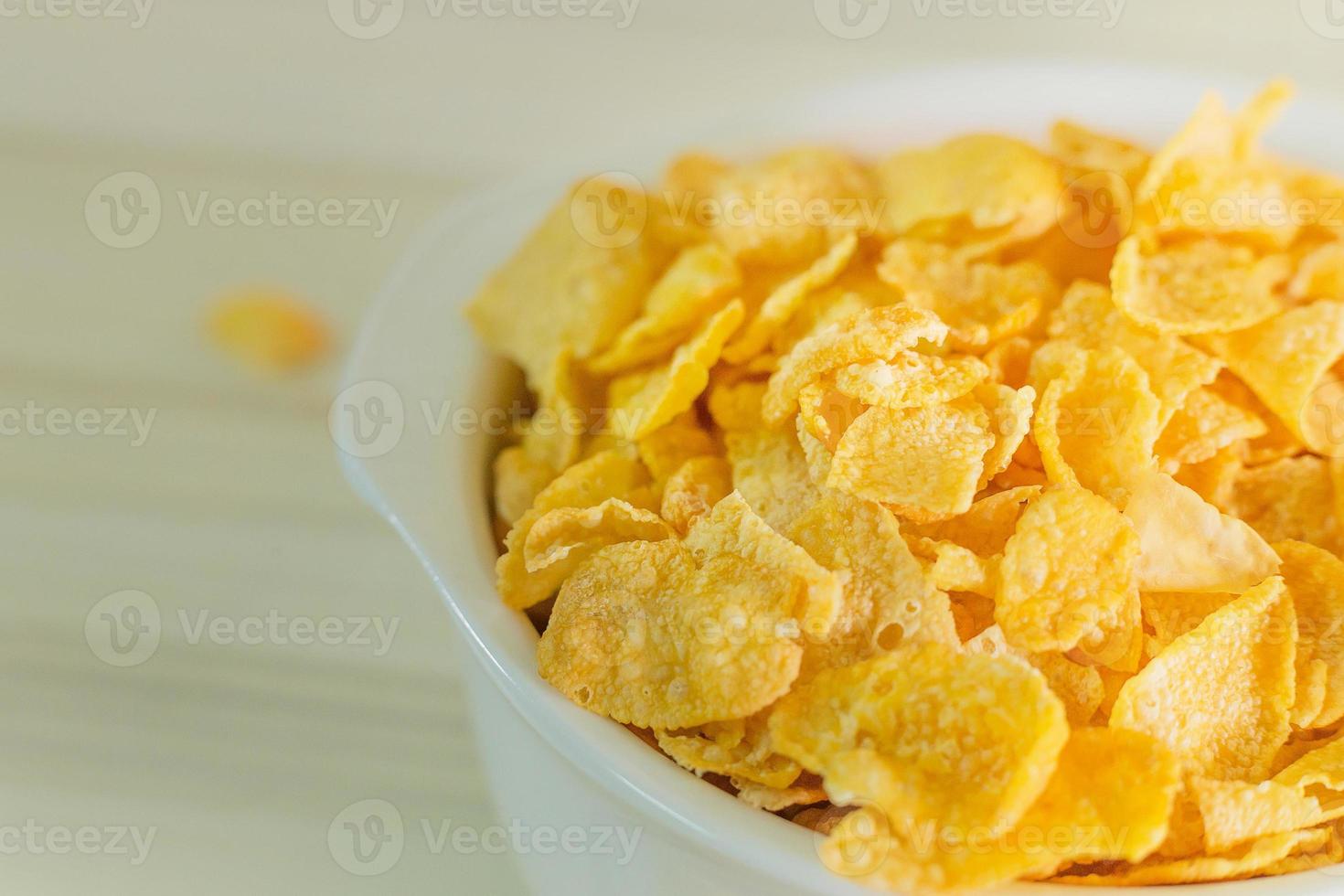 image  Close up Cornflakes cereal breakfast in white bowl on wooden table. photo