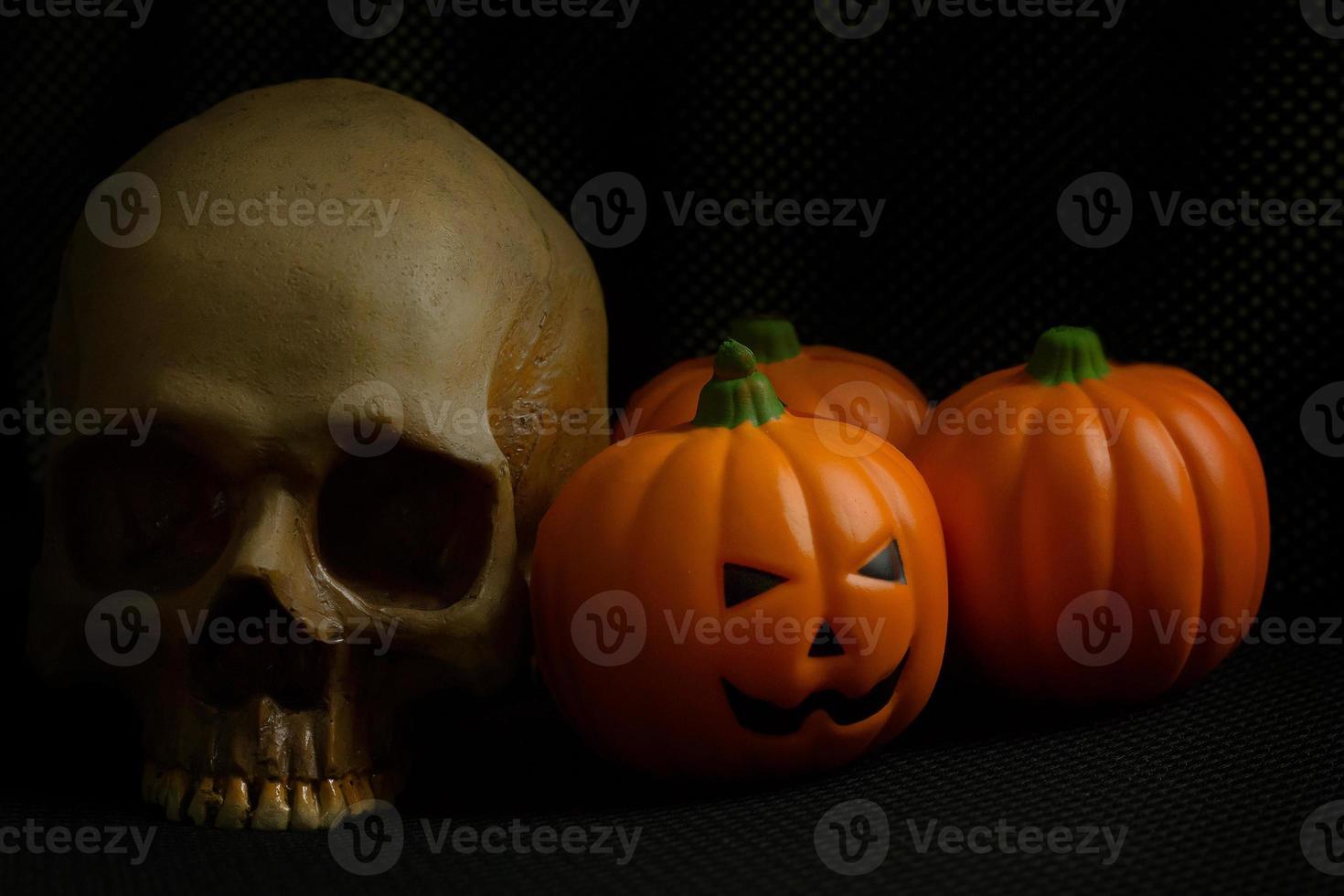 The halloween pumpkin jack and skull in black holiday background image. photo