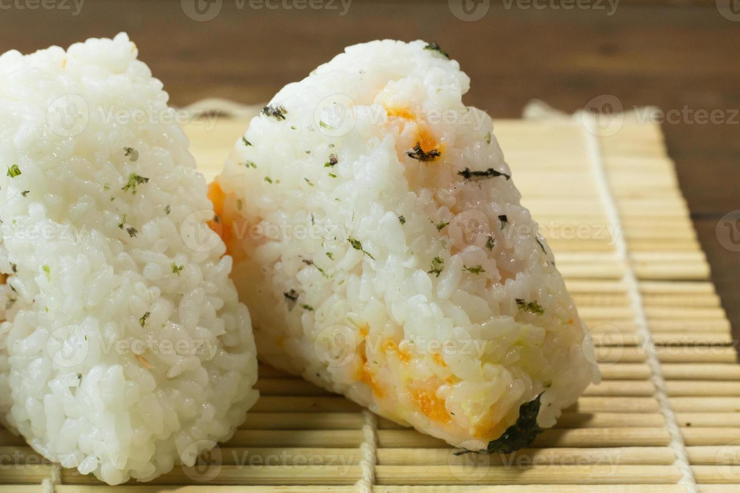 The Japanese food Onigiri  white rice formed into triangular or cylindrical shapes and often wrapped in nori. photo