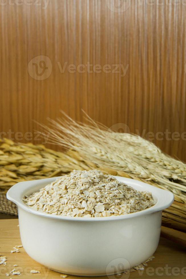 los copos de avena de cereales de desayuno saludables en un tazón sobre una mesa de madera. foto