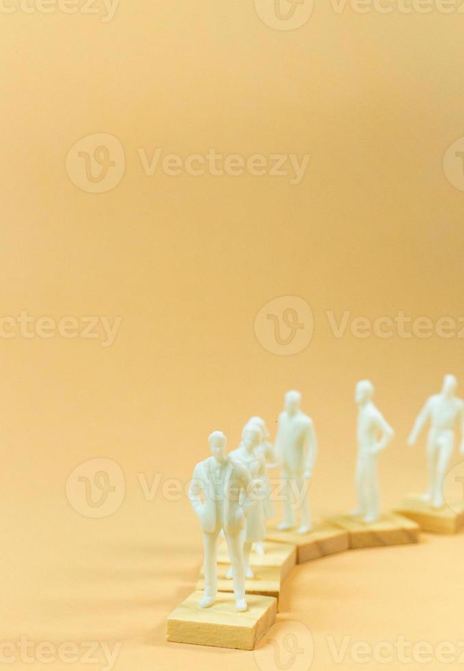 white  figure miniature on orange pastel for business content. photo