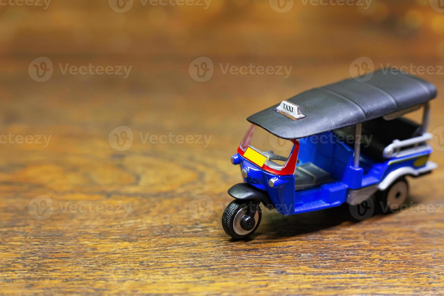 tuk tuk taxi  toy  on wood table close up image. photo
