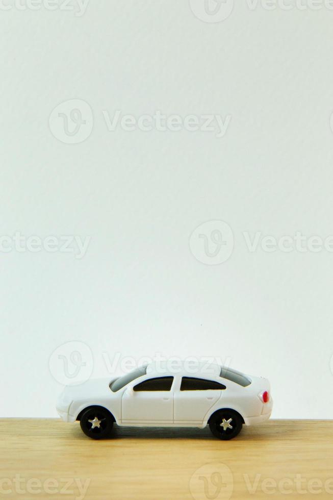 juguete de coche blanco en la imagen de la mesa de madera de cerca. foto