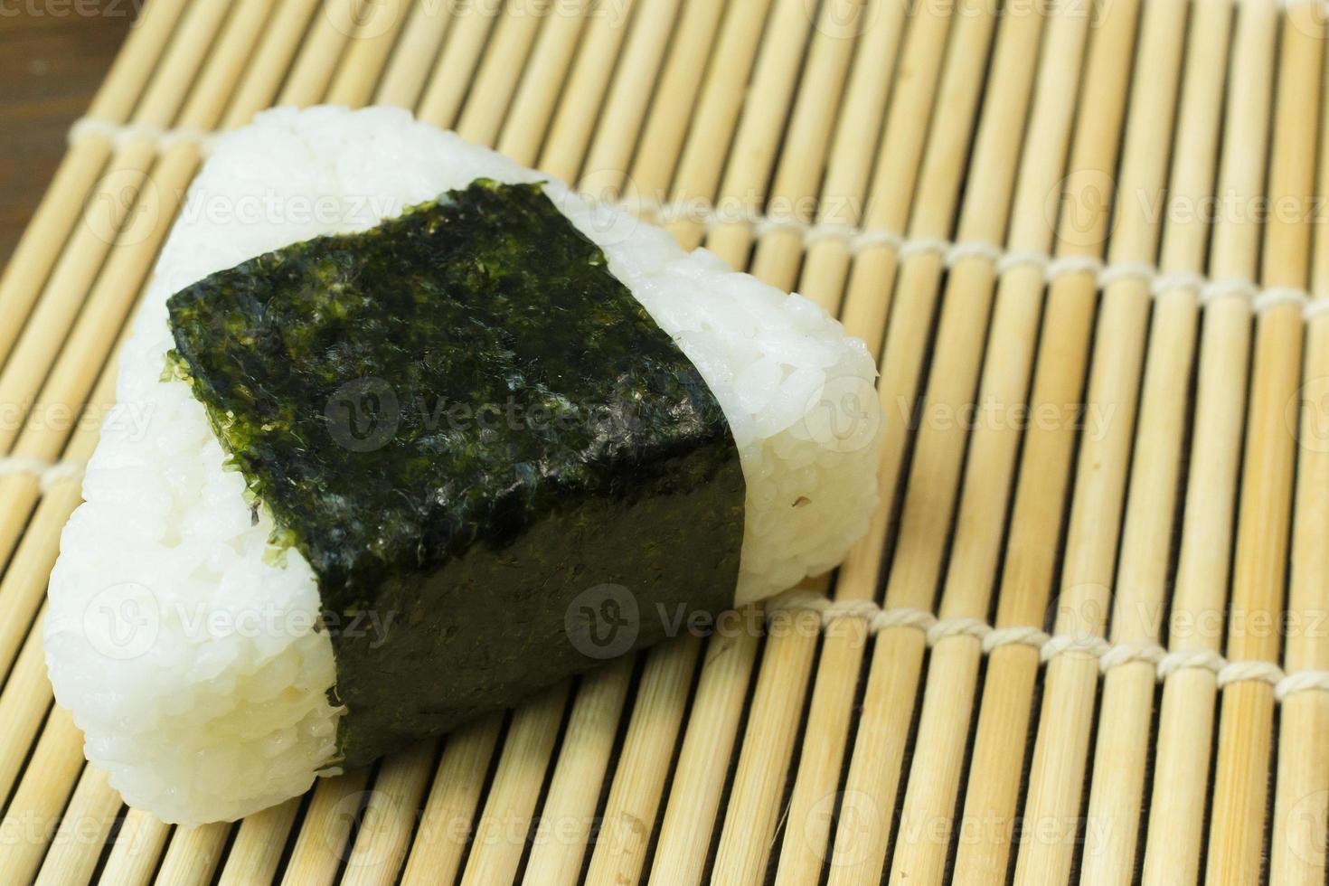 The Japanese food Onigiri  white rice formed into triangular or cylindrical shapes and often wrapped in nori. photo