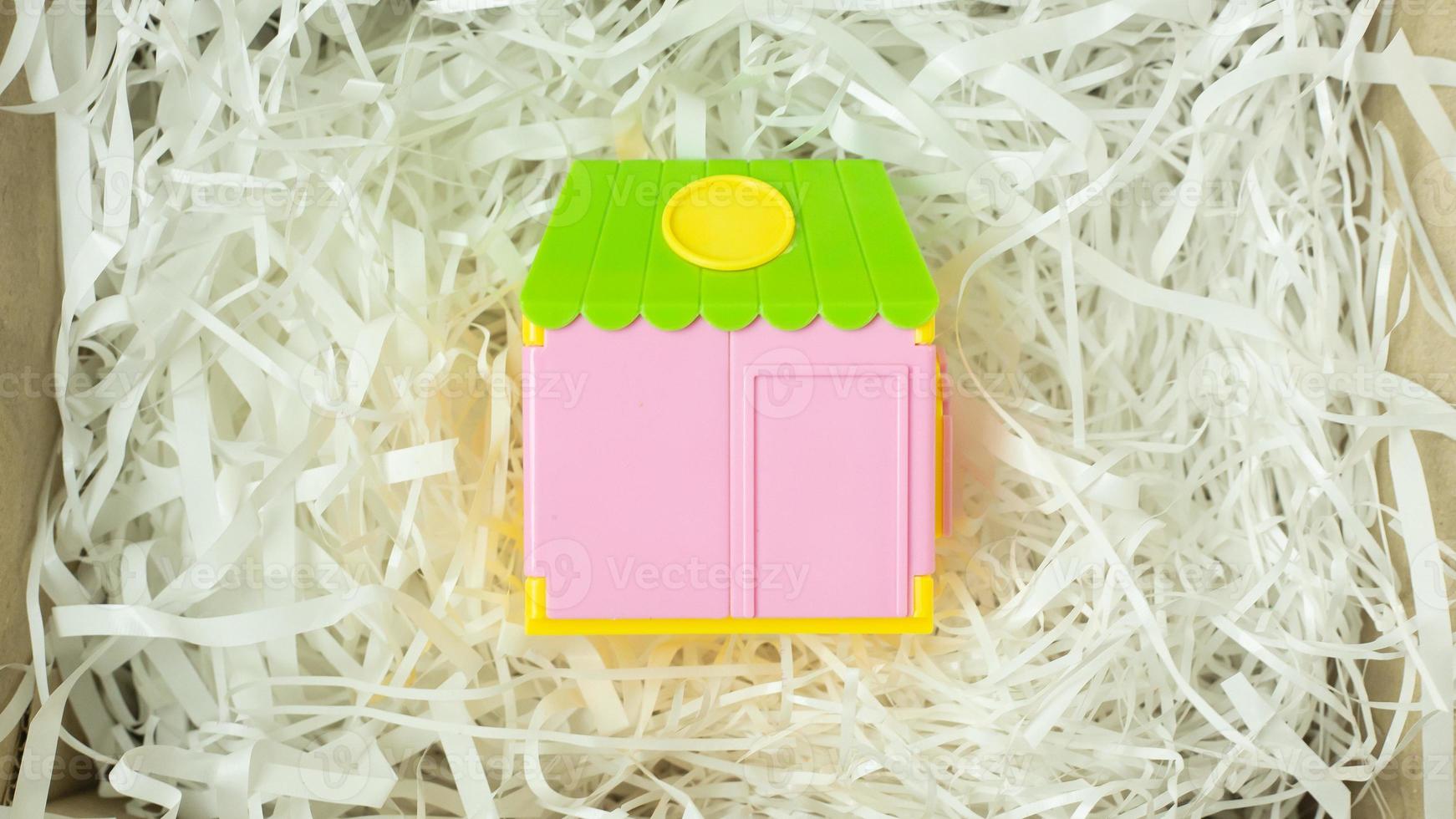 Toy home on Cushioning paper in box for home business content. photo