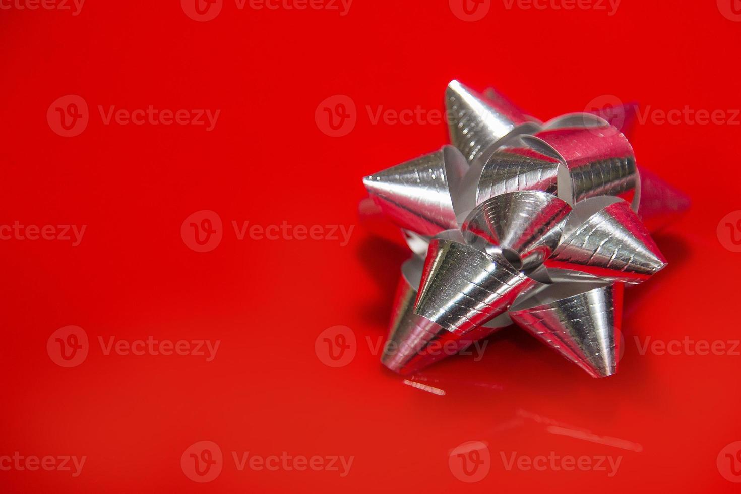 Shiny silver satin ribbon on red background. photo