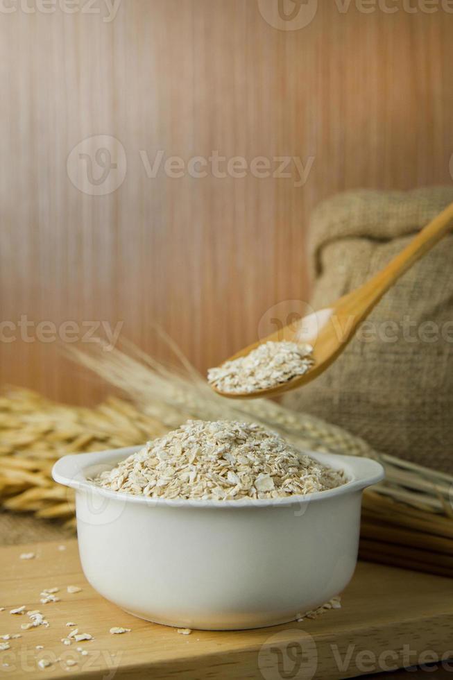 The Healthy breakfast cereal oat flakes in bowl on wooden table. photo