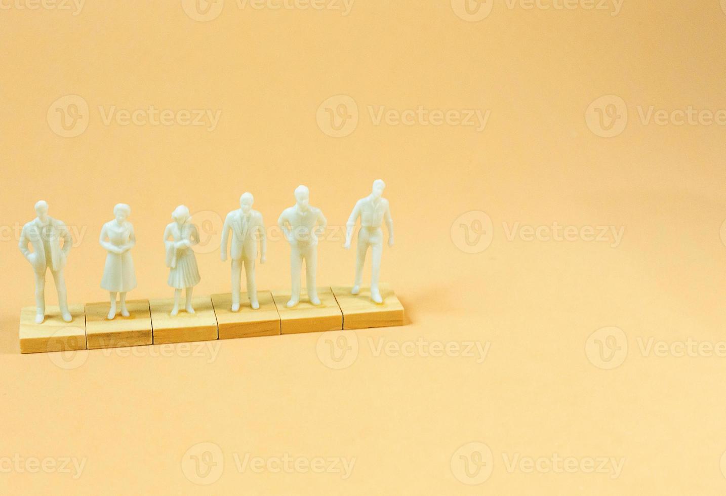 white  figure miniature on orange pastel for business content. photo