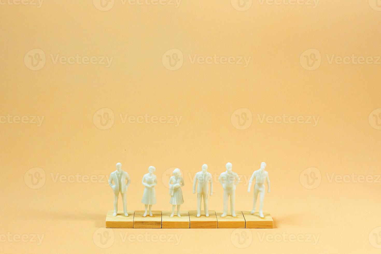 white  figure miniature on orange pastel for business content. photo