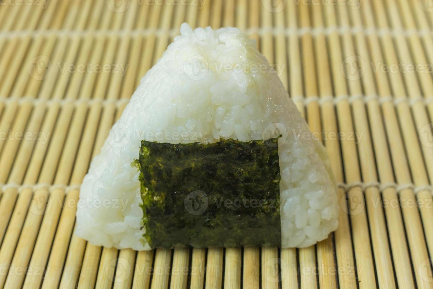 The Japanese food Onigiri  white rice formed into triangular or cylindrical shapes and often wrapped in nori. photo