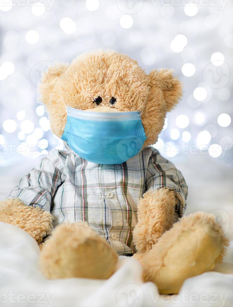 Teddy bear in a shirt and a blue medical mask photo