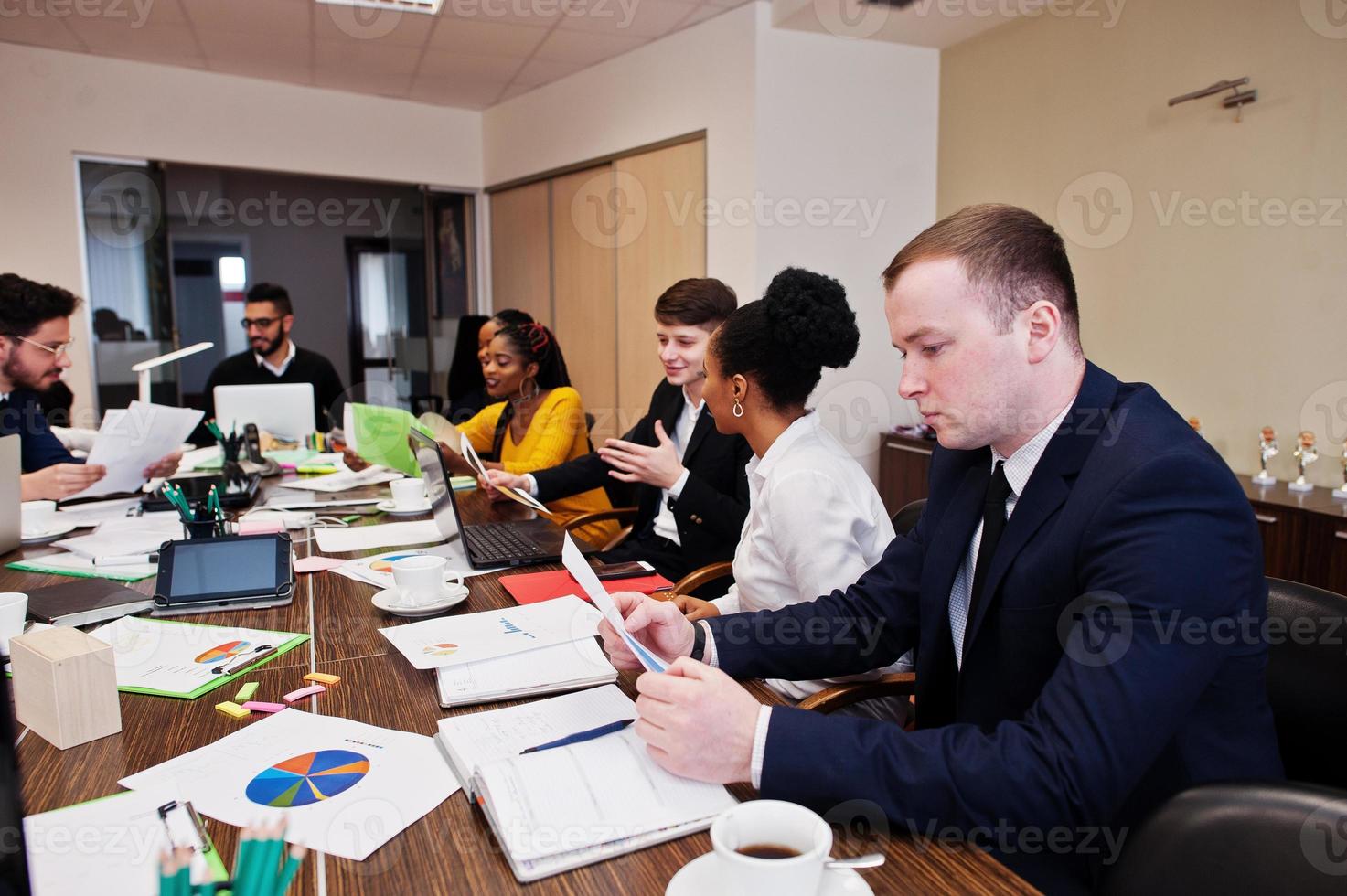 Multiracial young creative people in modern office. Group of young business people are working together with laptop, tablet. Successful freelancers team in coworking. photo