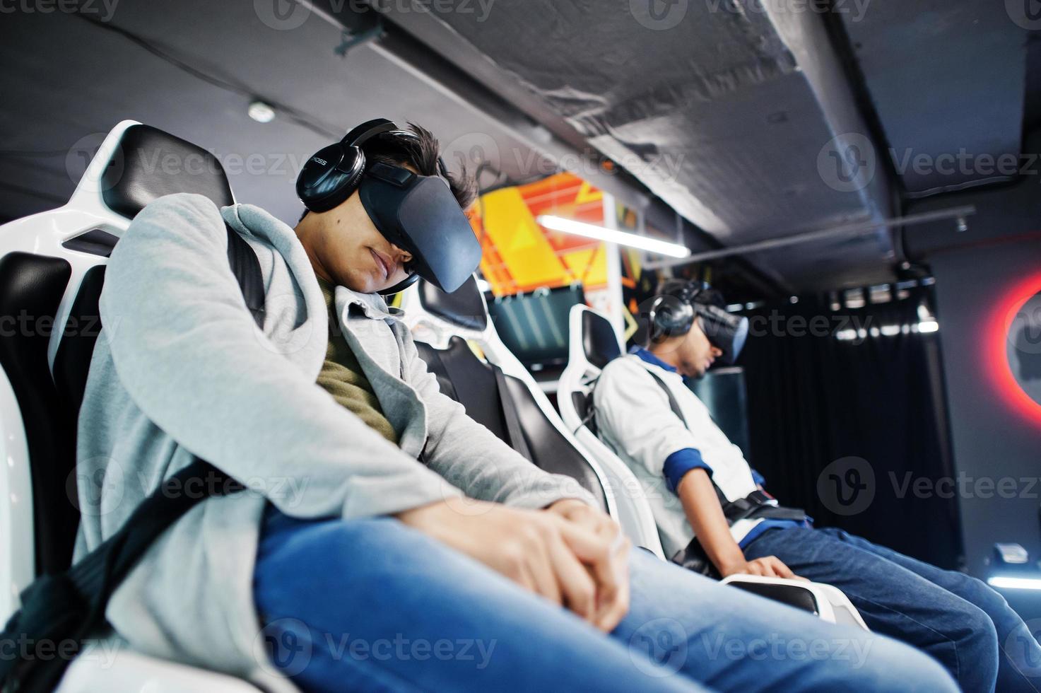 Two young indian people having fun with a new technology of a vr headset at virtual reality simulator. photo