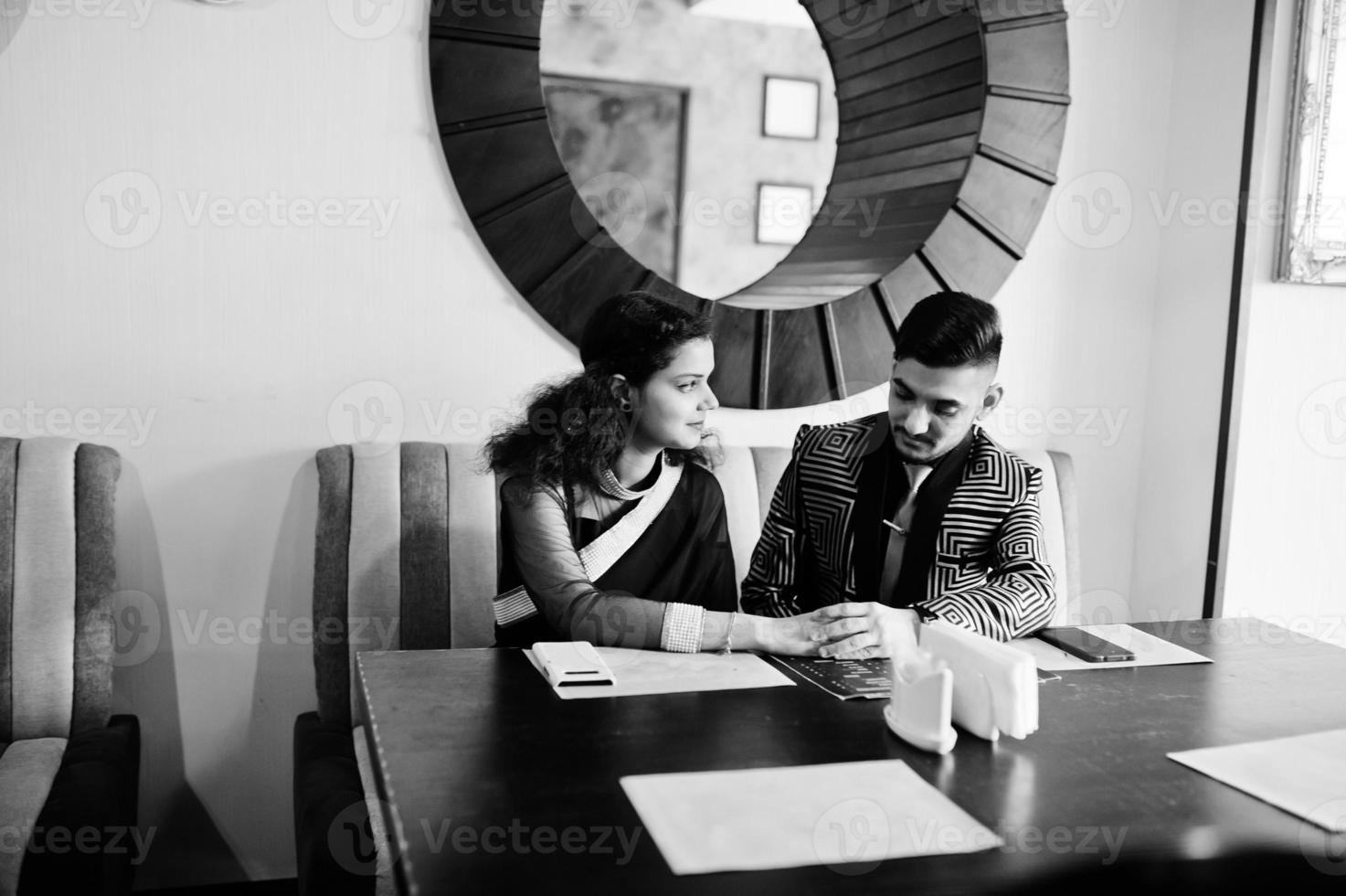 Lovely indian couple in love, wear at saree and elegant suit, posed on restaurant. photo