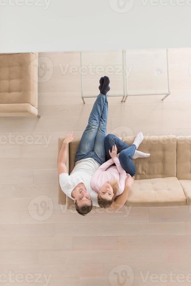 Young couple on the sofa watching television top view photo