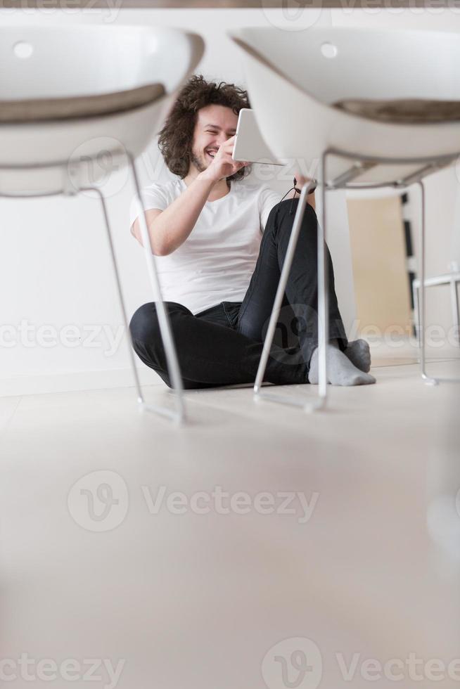 young man using a tablet at home photo