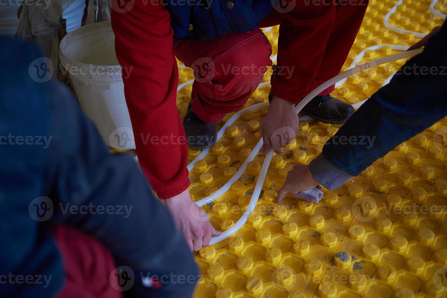 workers installing underfloor heating system photo