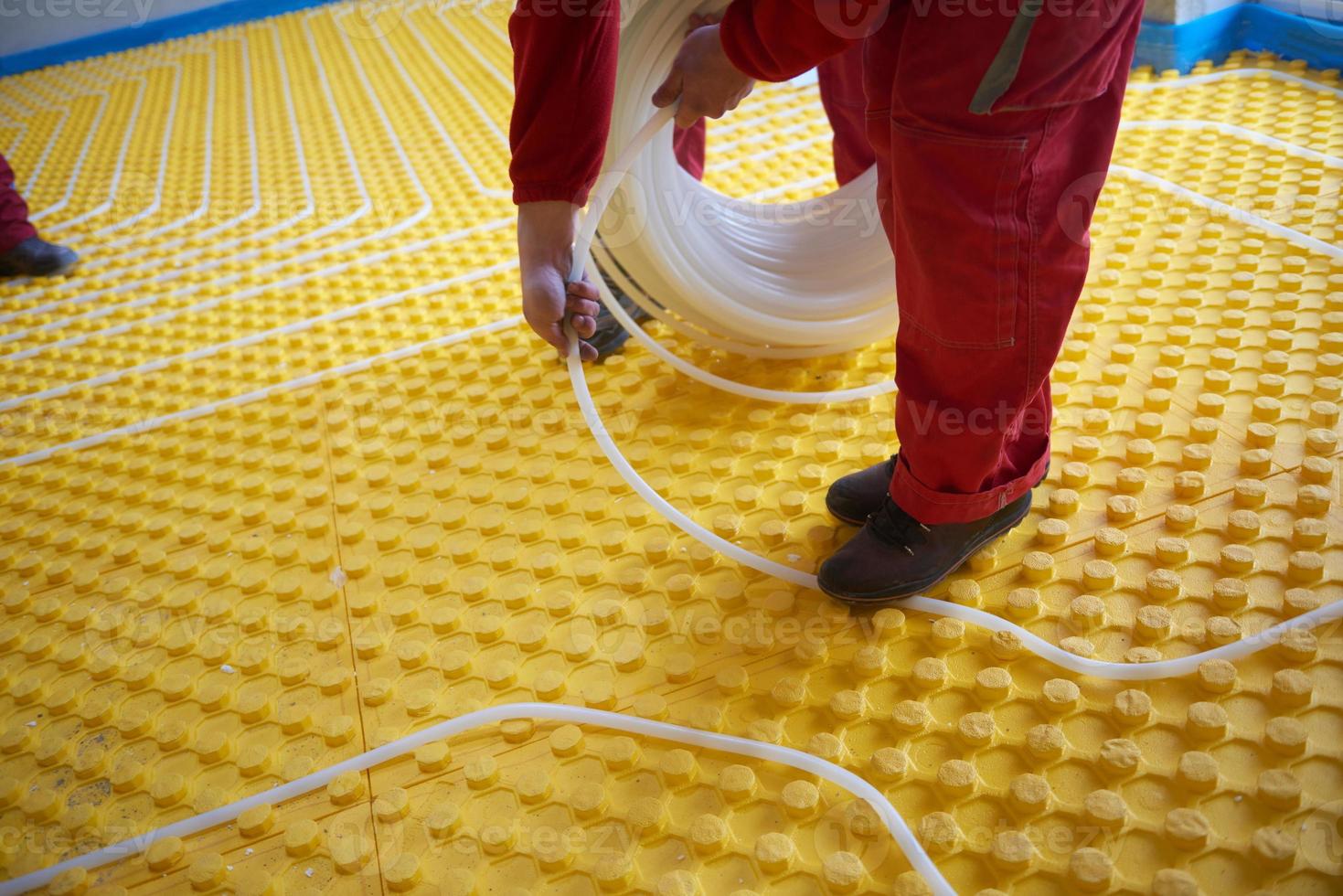 workers installing underfloor heating system photo