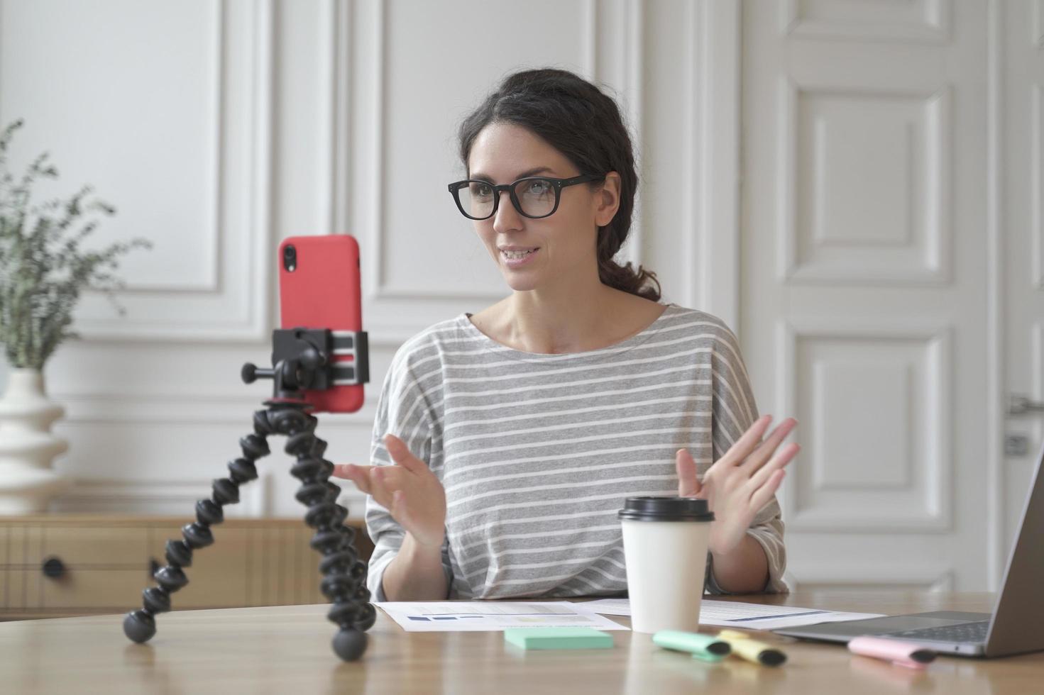 Confident Italian woman economist counselor recording video stream online using smartphone photo