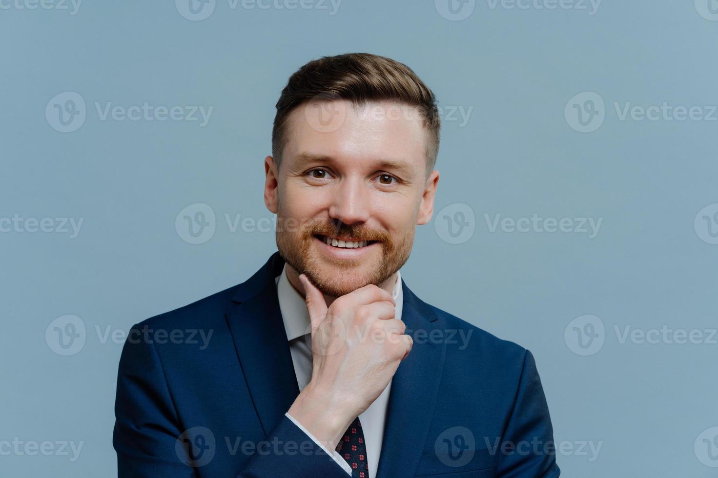 Captura de cabeza de exitoso hombre de negocios feliz en traje mirando a la cámara foto