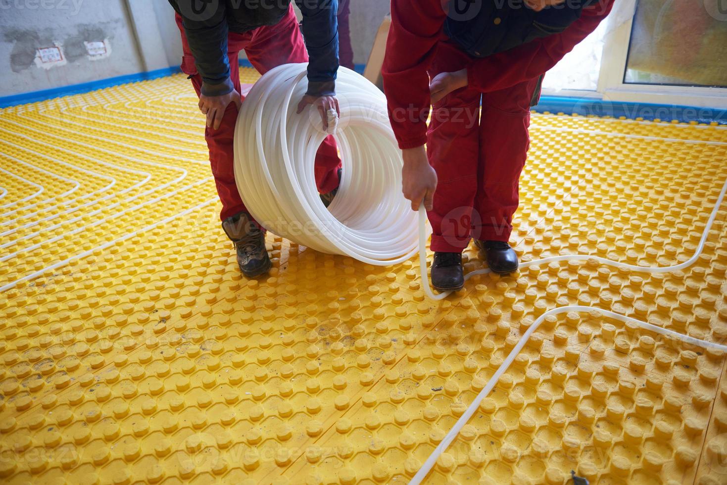 workers installing underfloor heating system photo