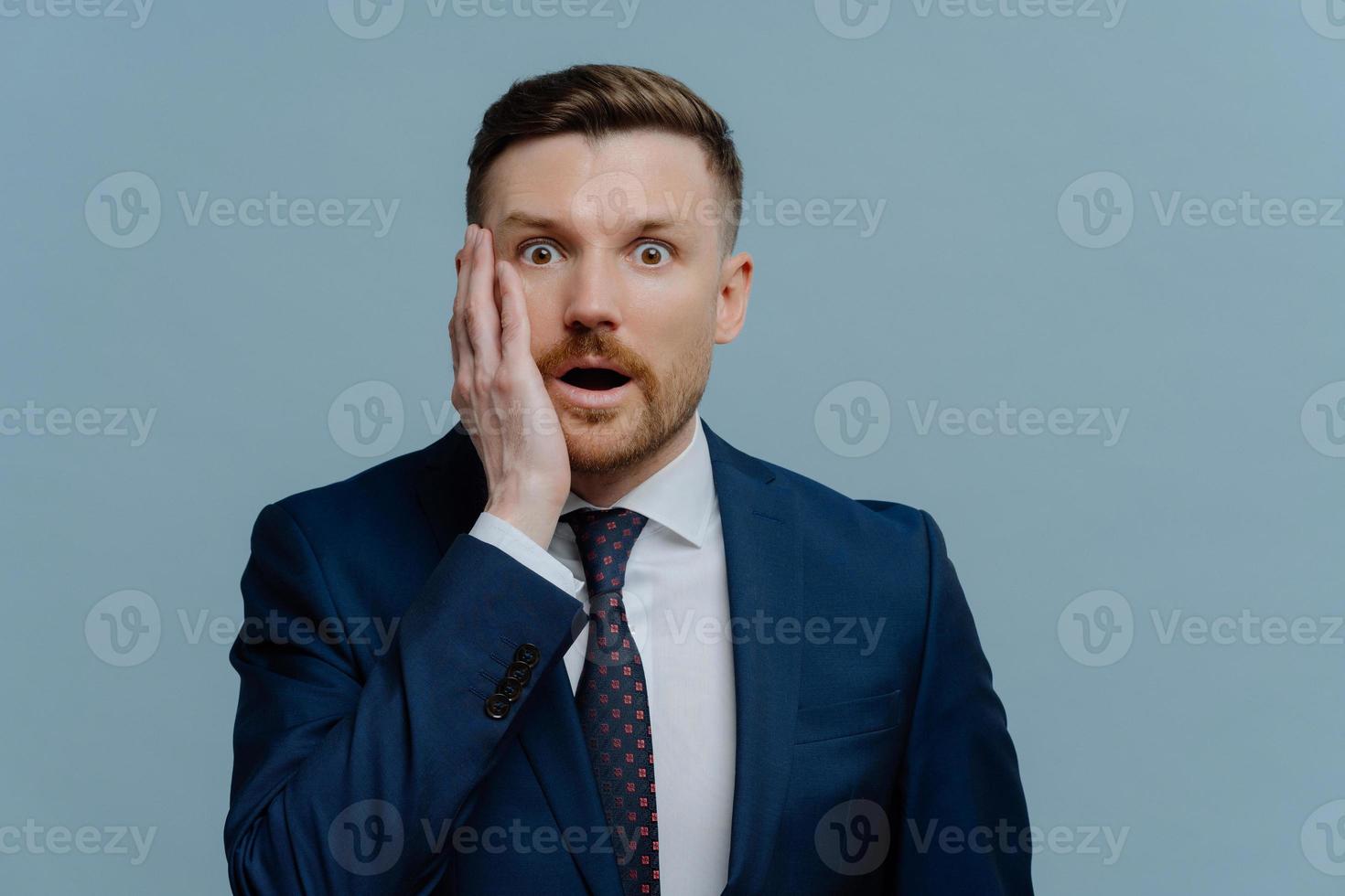 Surprised businessman receiving negative news and feeling shocked photo