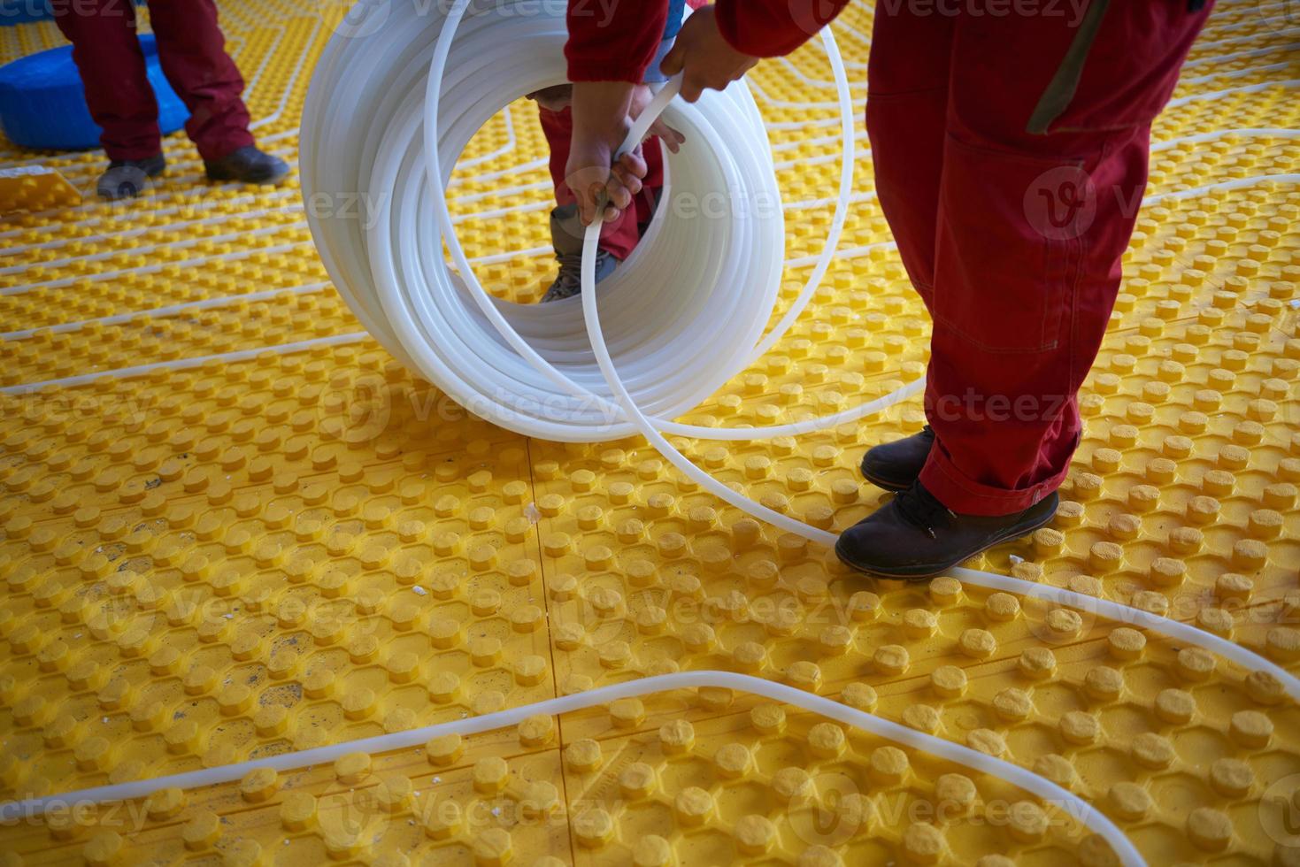 workers installing underfloor heating system photo