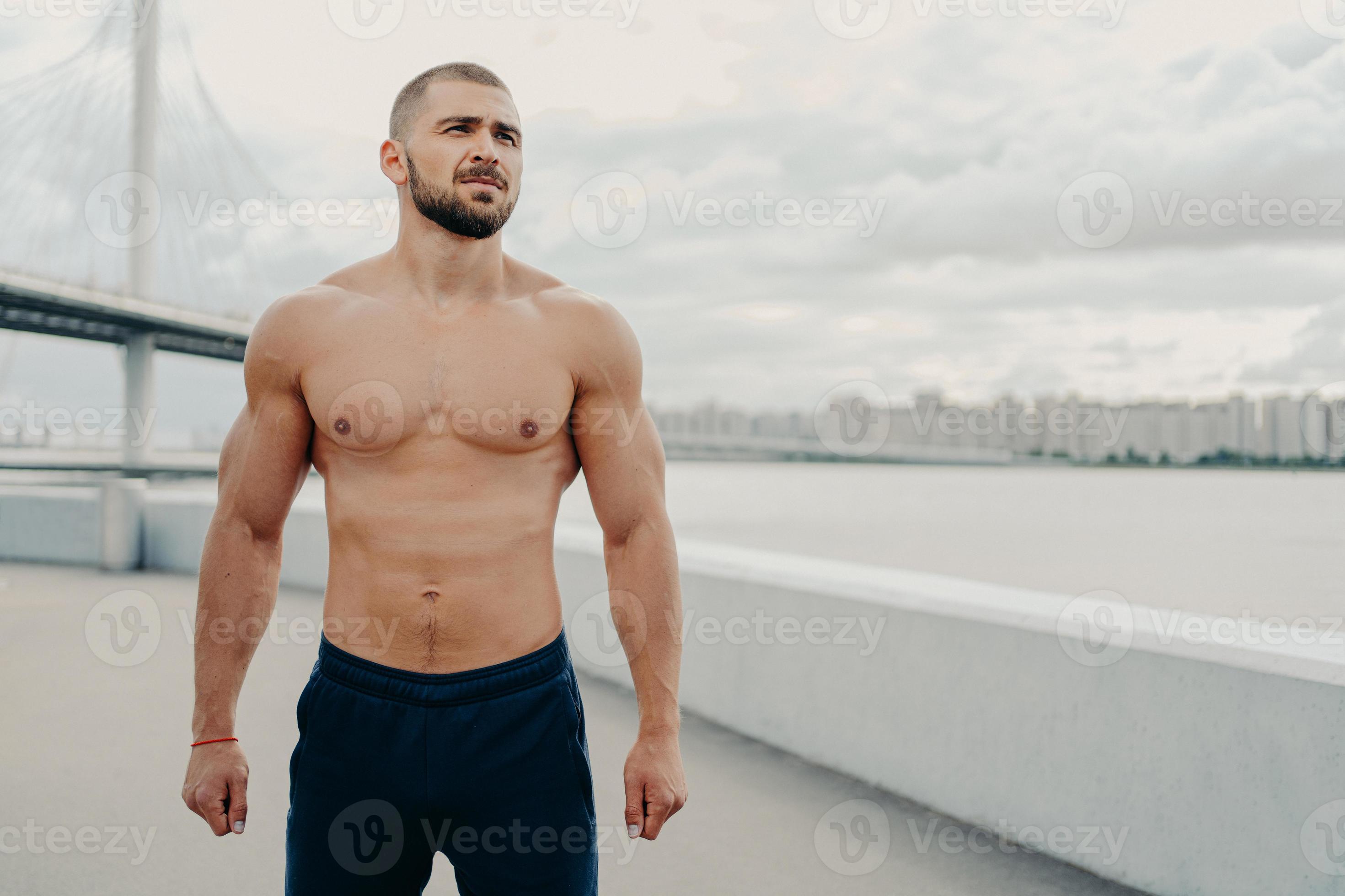 naked sport Young bearded athletic man with naked torso muscular body looks somewhere  into distance, dressed in sport shorts, rests during workout, poses outdoor  near river bridge. Fitness workout concept 10358685 Stock Photo at