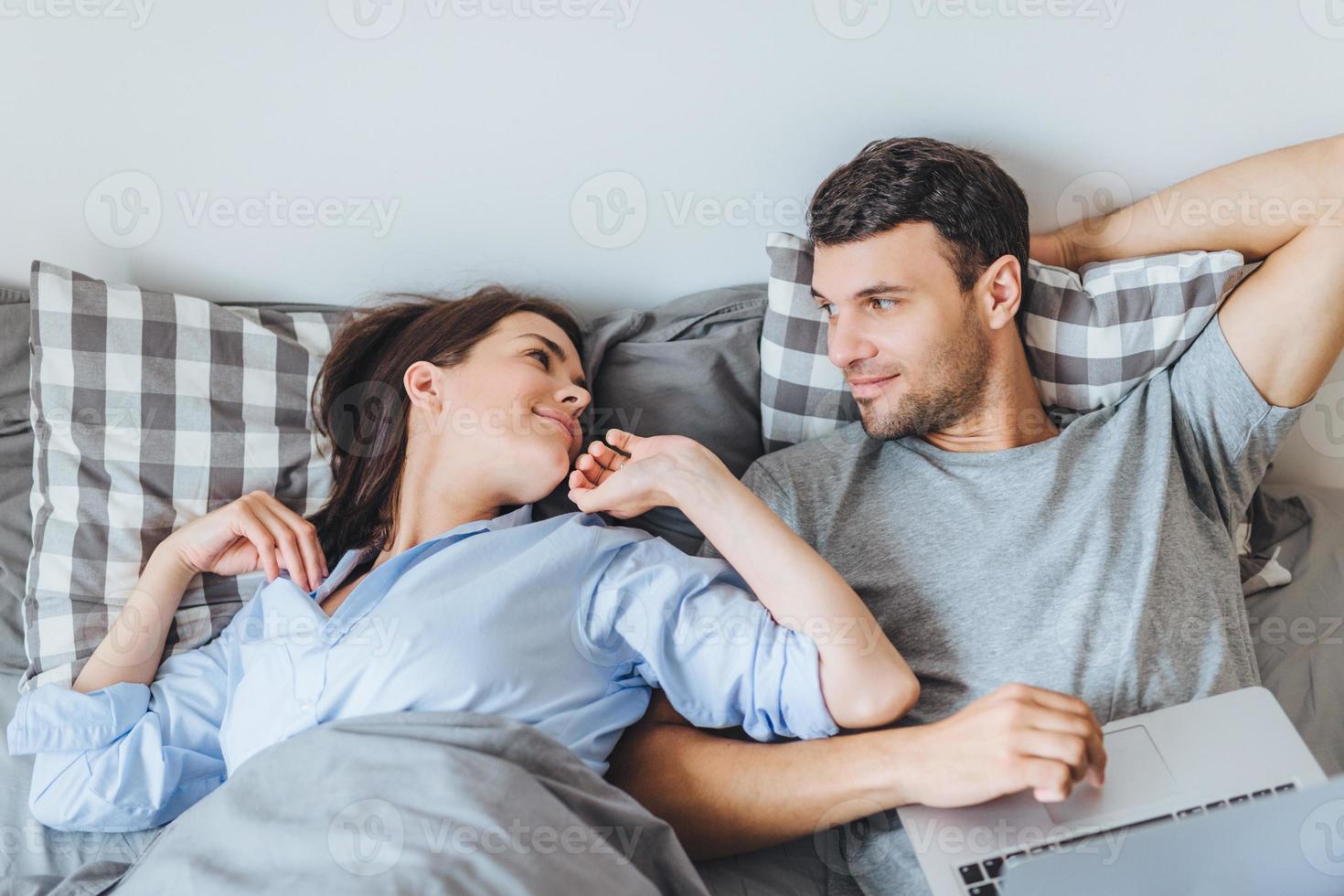 Beautiful woman looks with great love at her husband, just awake ...