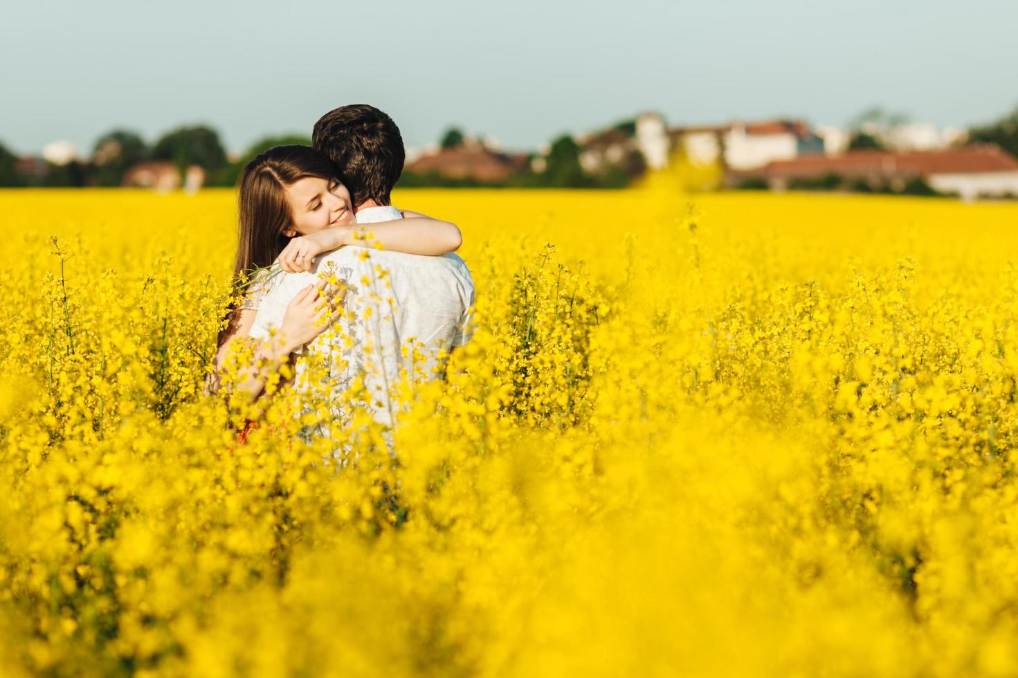 Passionate affectionate couple embrace each other, miss very much as havent seen for long time, spend wonderful summer day outdoor in yellow field. Romantic female and male hug with great love photo