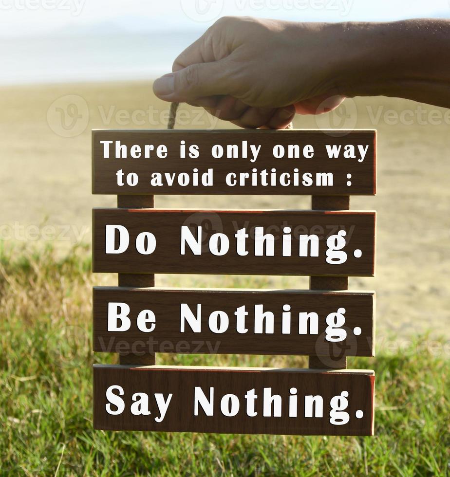 Hands holding wooden frame with motivational quote. photo