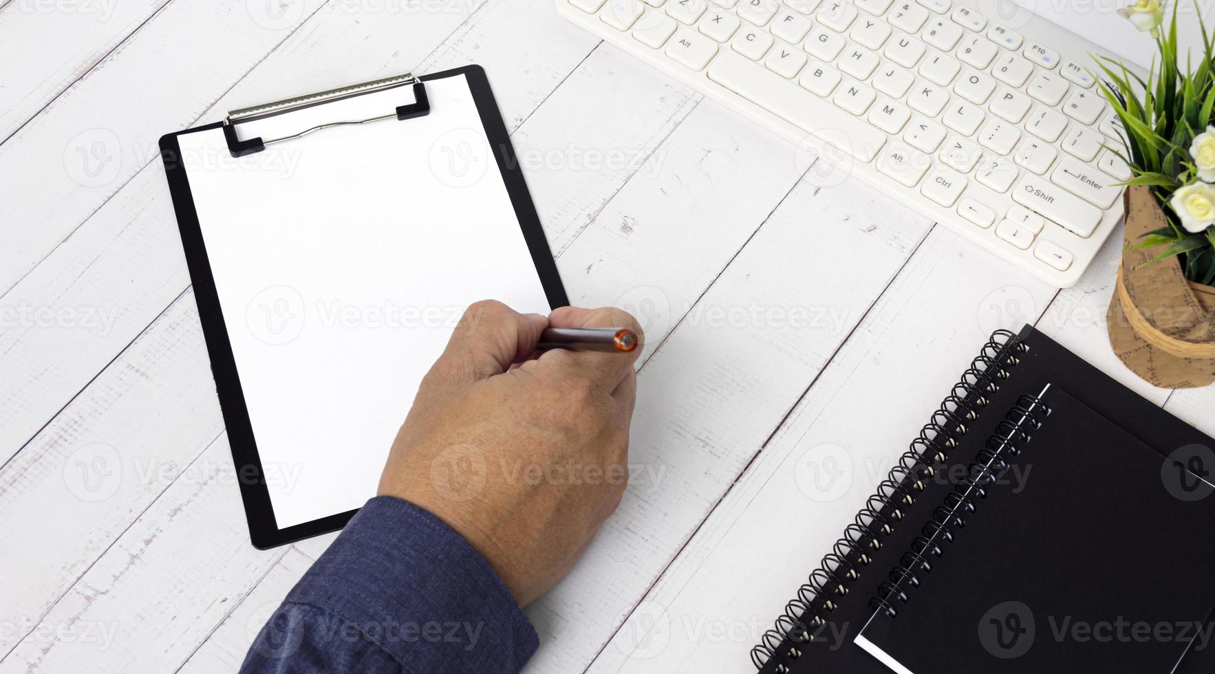 Businessman hands with pen writing notebook on office desk table. Copy space. photo
