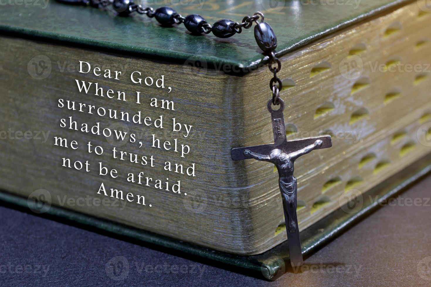Prayer with the cross over bible on wooden table with window light, vintage tone. photo