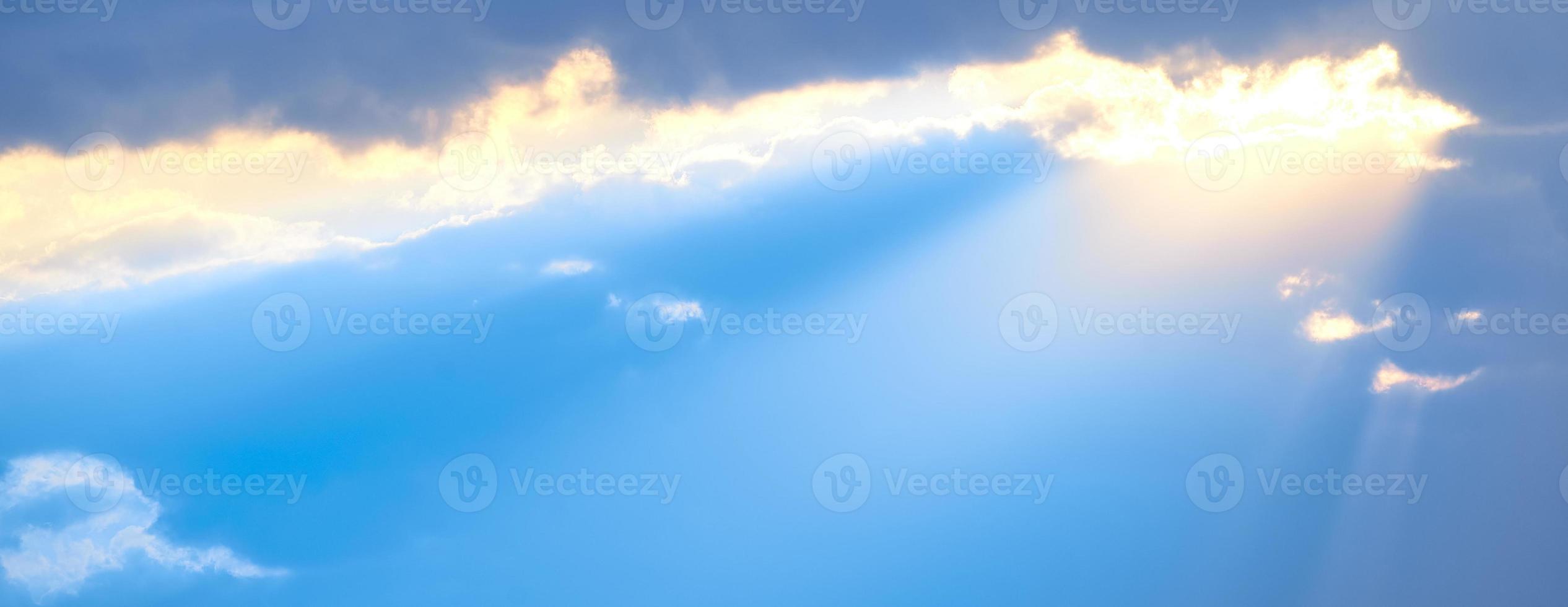 The sun's rays break through the blue clouds. The background of the sky. photo