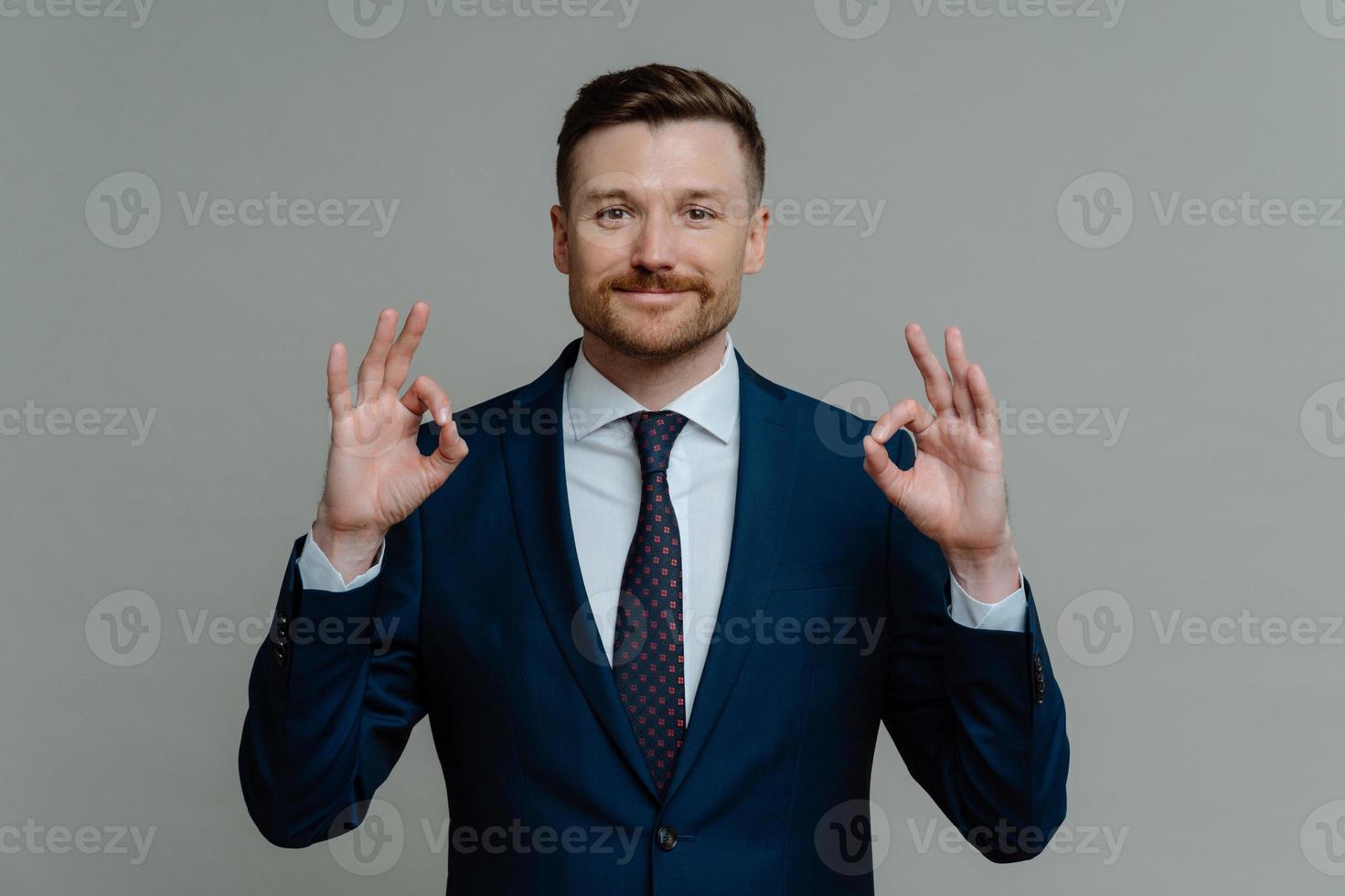 hombre de negocios feliz en traje que muestra que todo está bien foto