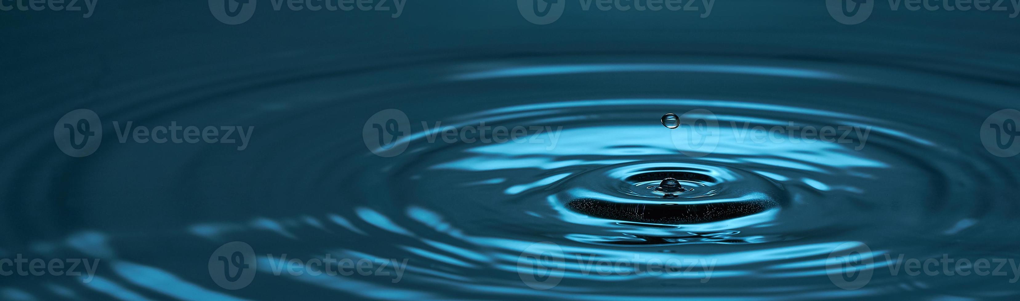 Water drop close up. Blue abstract background water drop and diverging circles. Photo with copy space.