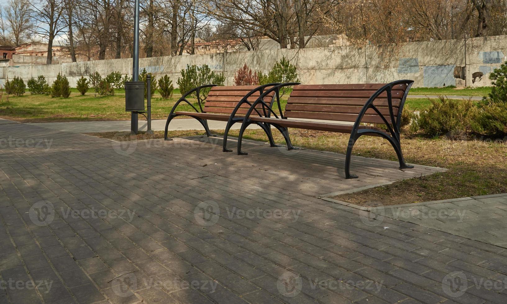 Empty benches near the path in the Park. Ban on walking due to threat of coronavirus. photo