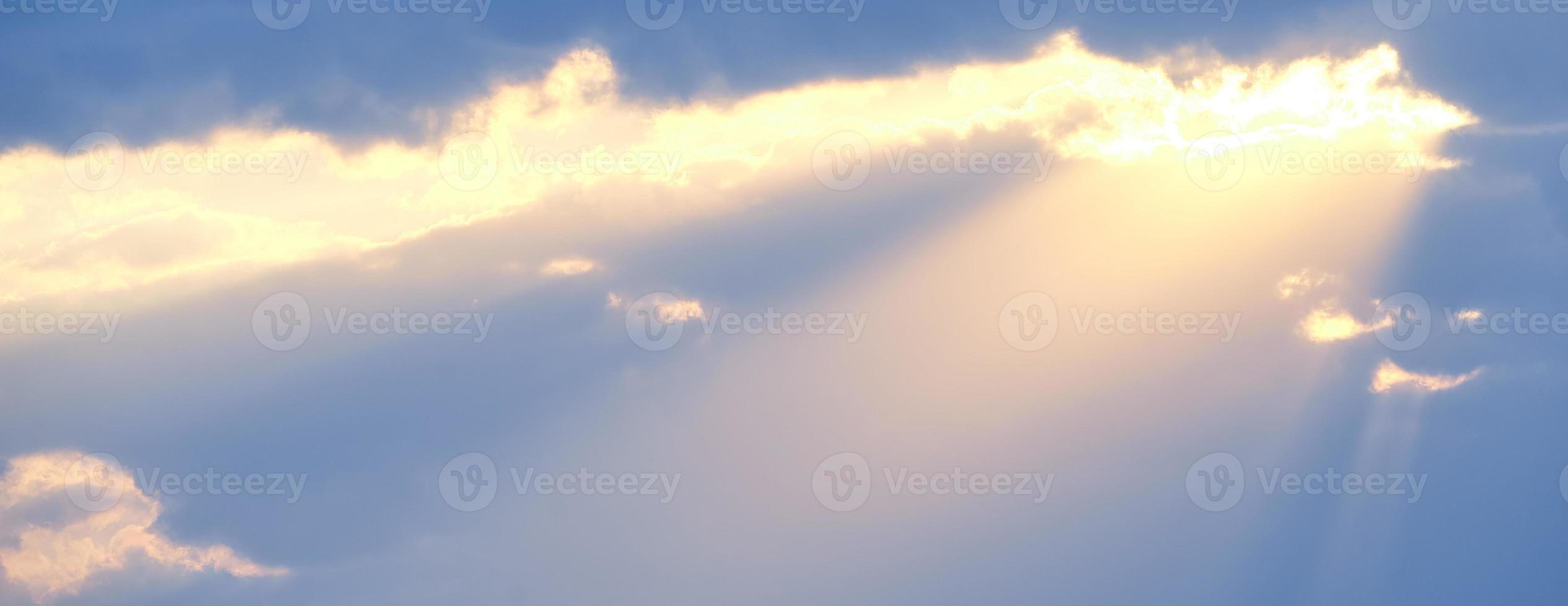 The sun's rays break through the blue clouds. The background of the sky. photo