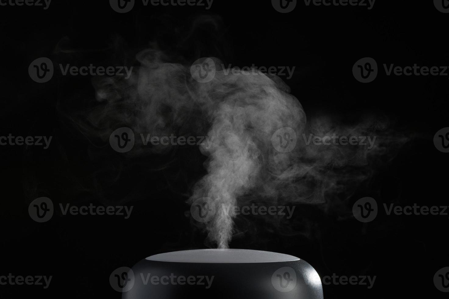 The concept of humidification of the air. Photo with copy space. Modern air humidifier on black background.