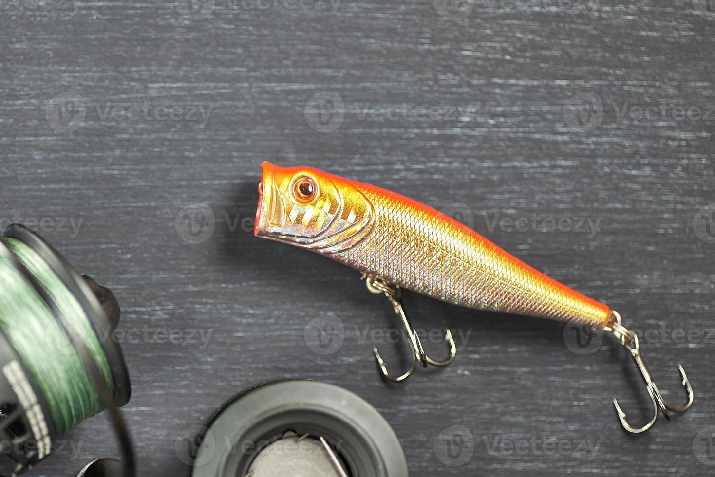 Fishing bait and reel on a wooden table. Fisherman's kit. photo