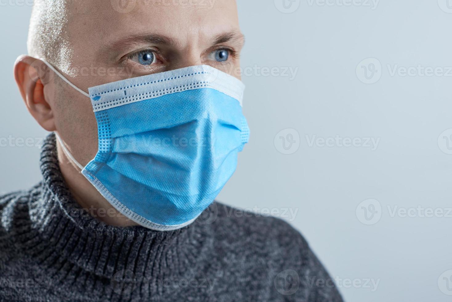 Man wearing protective mask on gray background. Photo with copy space.