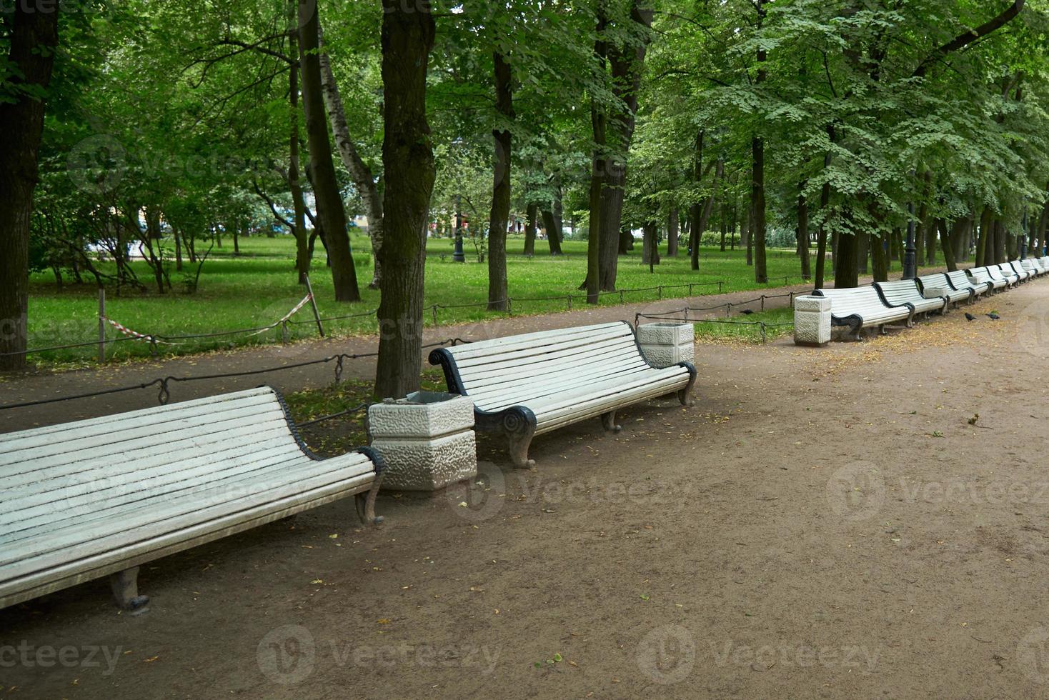 Empty benches near the path in the Park. Ban on visiting public places due to threat of coronavirus. photo
