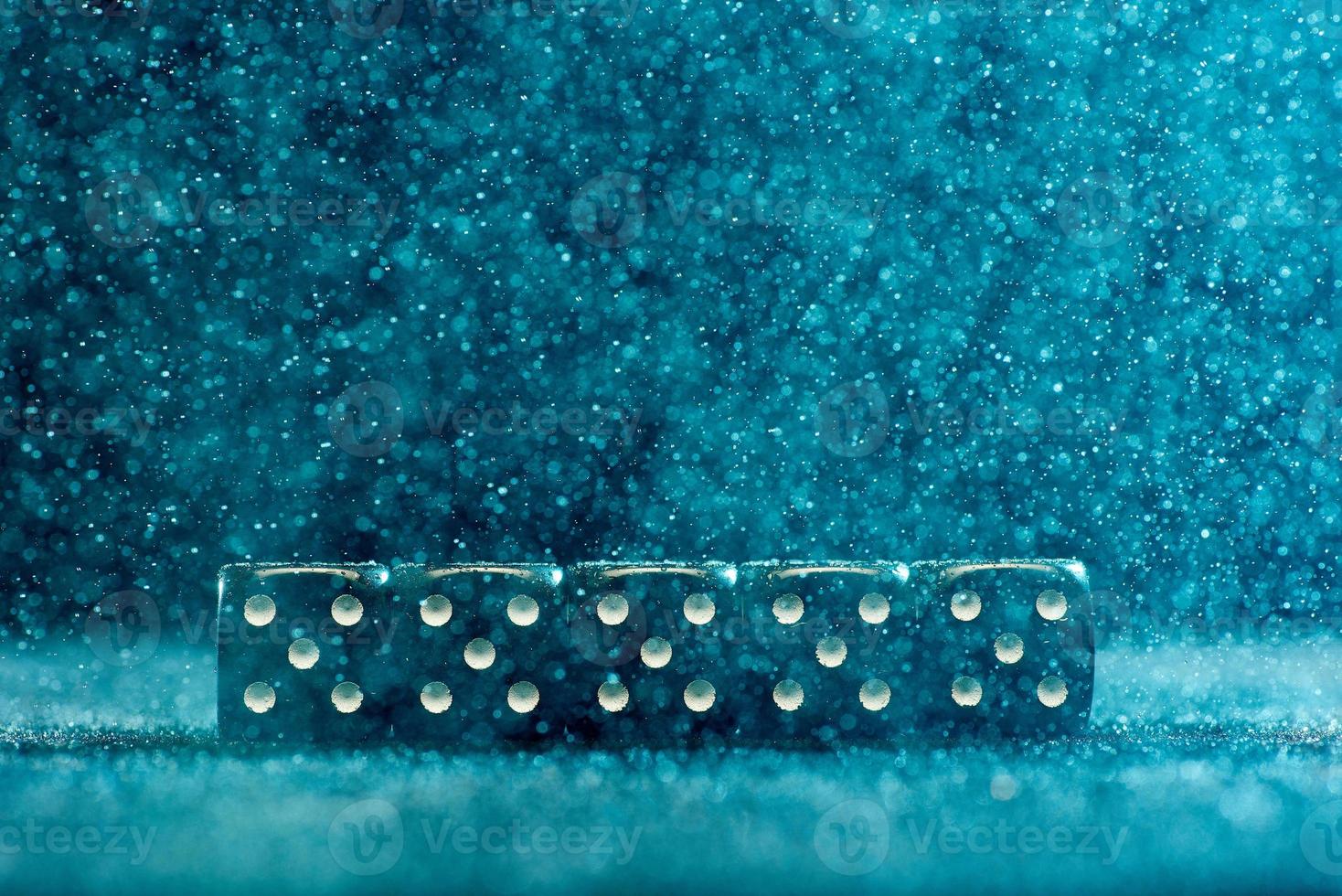 Game cubes are next to each other. Five identical black cubes on a blue background. Photo with bokeh.