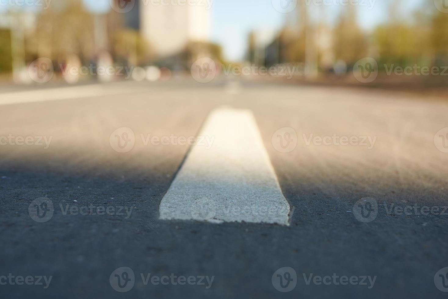 perspectiva de línea blanca. señalización vial en el fondo de la calle en desenfoque. foto