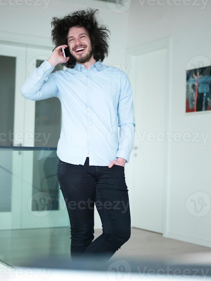 man using a mobile phone  at home photo