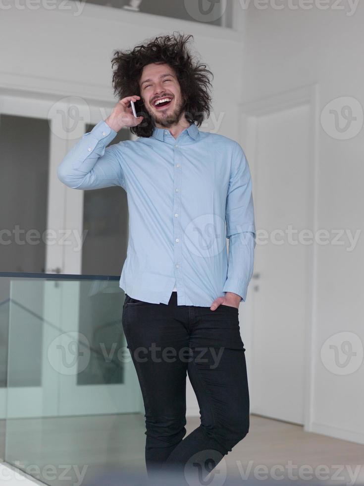 man using a mobile phone  at home photo